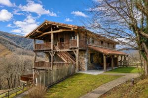 a log house with a porch and a balcony at Arantza Apartamentuak in Arantza