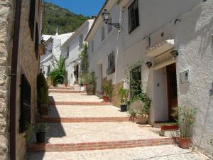 an alley of white buildings with potted plants at Apartamento La Font in Pego