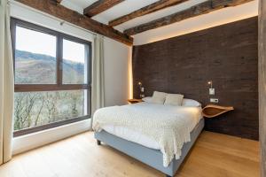 a bedroom with a bed and a large window at Arantza Apartamentuak in Arantza