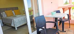 a room with a bed and a table and chairs at Vivenda os Silvas in Lagos