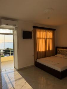 a bedroom with a bed with a window and a television at Aria Apartments in Borsh