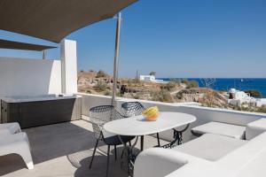 a balcony with a table and chairs and the ocean at Red Beach Harmony suites Modestos in Akrotiri