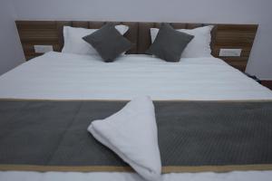 a large bed with white sheets and pillows at Hotel Subarnrekha Heritage- Lalpur, Kanke Road in Rānchī +20 photos