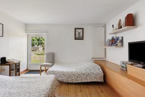 a bedroom with two beds and a flat screen tv at Chambres D'hôtes La Maison Rouge - in Contres +31 photos