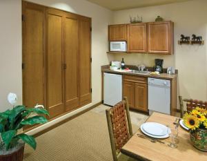 a kitchen with a table and a kitchen with a counter at CW Taos Resort Two 1BR Suites in Taos