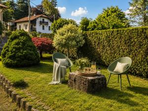 a garden with two chairs and a table on the grass at Lavanda Cozy Apartment near Lake Como and Lugano in Lanzo dʼIntelvi