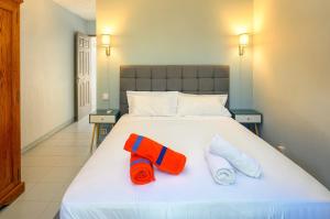 a bed with two towels sitting on top of it at Beachfront Duplex with Estate Pool in Bain Boeuf