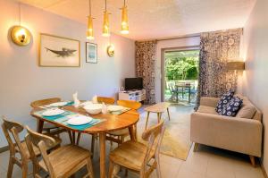 a dining room and living room with a table and chairs at Beachfront Duplex with Estate Pool in Bain Boeuf