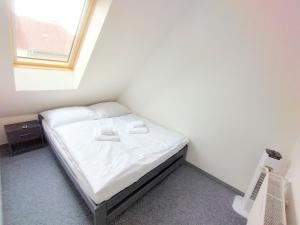 a small bed in a room with a window at Duplex with garden in Prague +10 photos