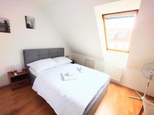 a bedroom with a white bed and a window at Duplex with garden in Prague