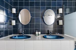 a bathroom with two sinks and two mirrors at Coeur de Ville - Beaugency in Beaugency +23 photos