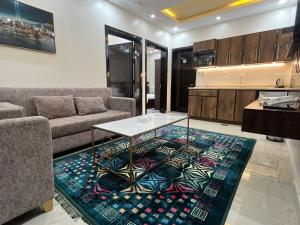 a living room with a couch and a table on a rug at منتصف البيعة للشقق المخدومة in Taif