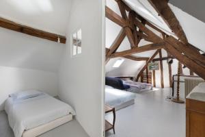 a attic bedroom with two beds and wooden beams at Coeur de Ville - Beaugency in Beaugency