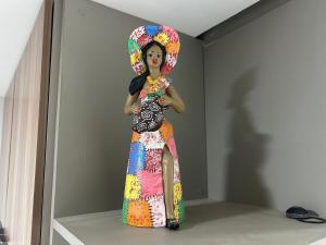 a woman in a colorful dress standing in a room at Flat no centro VDP314 - Rooftop in Porto De Galinhas