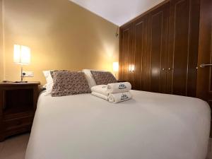 a bedroom with a large white bed with pillows at AC Apartaments Comapedrosa Canillo in Canillo