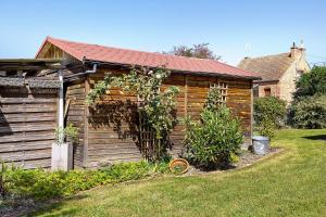 a wooden house with a garden in the yard at Chalet La Bienvenue in Vouzon
