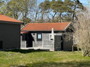 a small cabin with an orange roof in a yard at Brissundsbyn in Visby