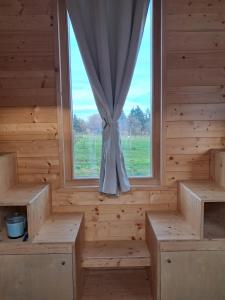 a room with a window with benches and a curtain at Tiny Mélisse in Leimbach