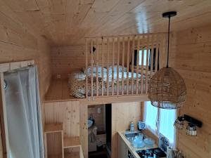 a bedroom in a log cabin with a bed and a refrigerator at Tiny Mélisse in Leimbach