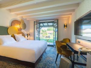a hotel room with a bed and a balcony at Mercure Auxerre Autoroute du Soleil in Appoigny +92 photos