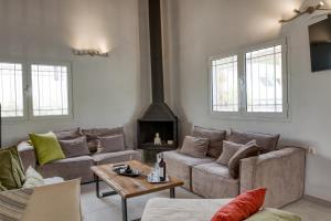 a living room with two couches and a fireplace at Sahara Blanc Villa - Private Pool - Loft Space in Spiliazéza