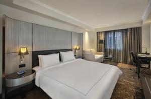 a hotel room with a large white bed and a desk at Park Plaza London Victoria in London