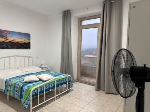 a bedroom with a bed and a window and a fan at La Funtanella in Aggius +18 photos