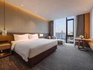 a hotel room with a large bed and a desk at MOVENPICK TASHKENT OLD CITY in Tashkent