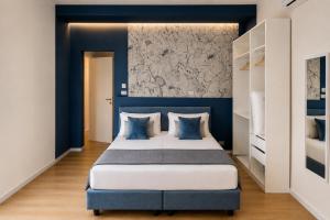 a bedroom with blue walls and a bed with blue pillows at Sfreg Suites Magenta - Camere e B&B in Magenta