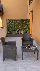 a patio with two chairs and a table and a hedge at Sfreg Suites Magenta - Camere e B&B in Magenta