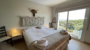 a bedroom with a large bed and a large window at Casa Loto in Pals +36 photos
