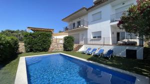 a villa with a swimming pool in front of a house at Casa Loto in Pals