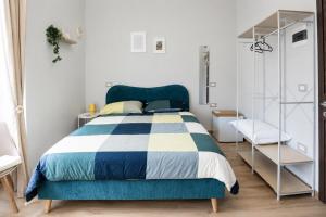 a bedroom with a bed with a blue and white comforter at Fuoribinario B&B in San Felice a Cancello +4 photos