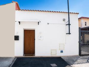 a white building with a brown door at Fuoribinario B&B in San Felice a Cancello