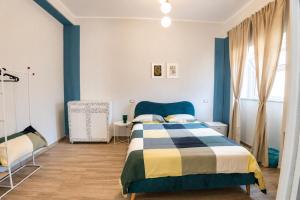 a bedroom with a blue and white bed and a window at Fuoribinario B&B in San Felice a Cancello