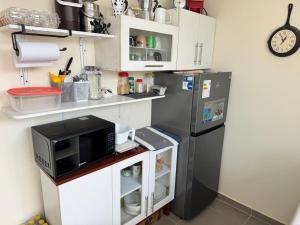 a kitchen with a refrigerator and a microwave at Alojamiento en Chilca in Salinas +19 photos