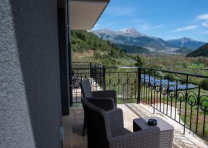 a balcony with two chairs and a view of mountains at Montiva GuestHouse in Karpenisi