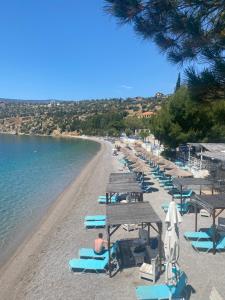 a beach with chairs and umbrellas and the water at Apartment Antikyra in Antikyra