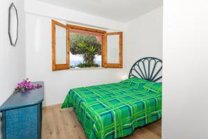 a bedroom with a bed and a window at Paradise Residence Garden in SantʼAlessio Siculo