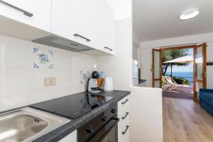 a kitchen with a sink and a view of the ocean at Paradise Residence Garden in SantʼAlessio Siculo