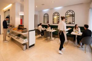 a group of people sitting at tables in a restaurant at Duque Hotel Boutique & Spa in Buenos Aires +55 photos