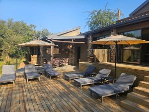 a deck with chairs and umbrellas on a house at Nkinga River Lodge in Balule Game Reserve