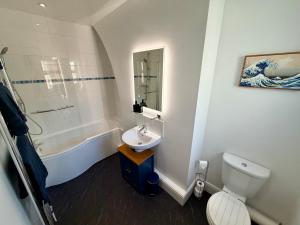 a bathroom with a sink and a toilet and a tub at Salisbury City Centre Cottage in Salisbury