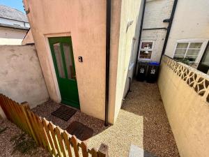 a green door on the side of a house at Salisbury City Centre Cottage in Salisbury