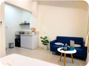 a living room with a blue couch and a table at Santo house in Thôn Trường Giang +33 photos