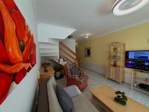a living room with a couch and a tv at Playa del Cura - Beachside Retreat in Playa del Cura