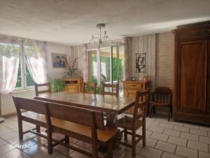 a dining room with a wooden table and chairs at Maison de campagne à Balaives et Butz in Flize