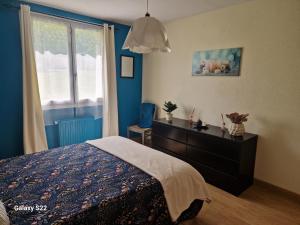 a bedroom with a bed and a dresser and a window at Maison de campagne à Balaives et Butz in Flize