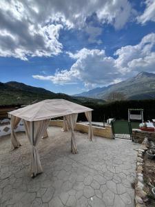 acovered table on a patio with mountains in the background at Casa La Ferrata in Jimera de Líbar