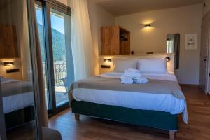 a bedroom with a bed with towels on it at Montiva GuestHouse in Karpenisi